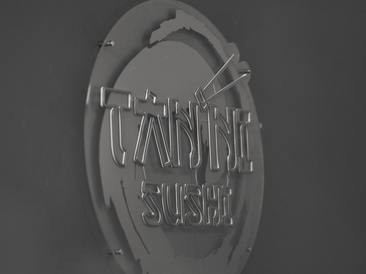 Interior del local de Tanni Sushi en Elche con el cartel iluminado del logo